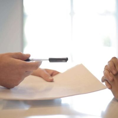 contract a person holding a pen over a paper