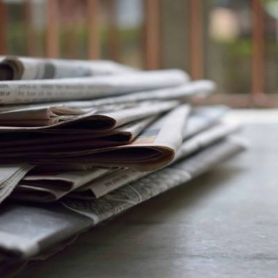 pexels-photo-518543-518543 A close-up of a stack of newspapers resting on a desk, symbolizing information and media.