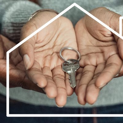Hands of a couple holding a house key symbolizing home ownership and new beginnings.